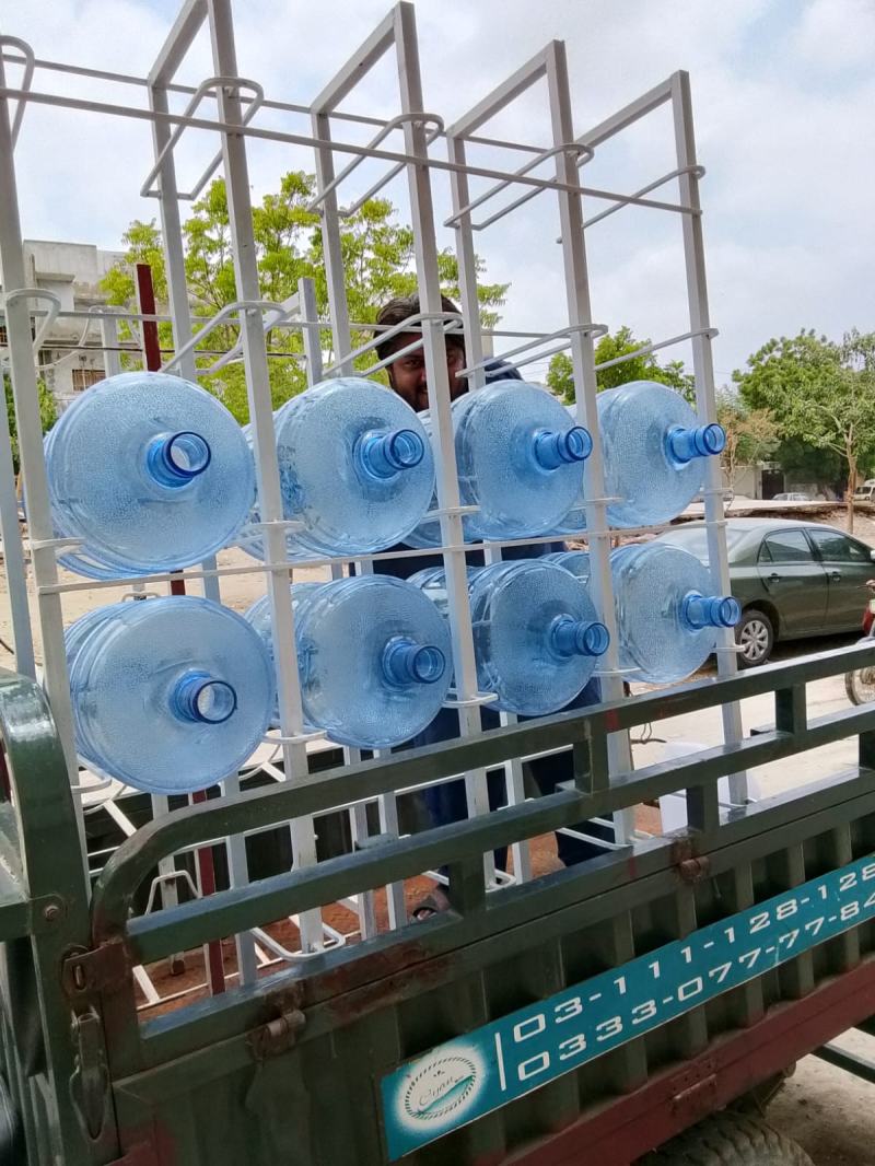 Loader with a steel rack of 19 litre bottles