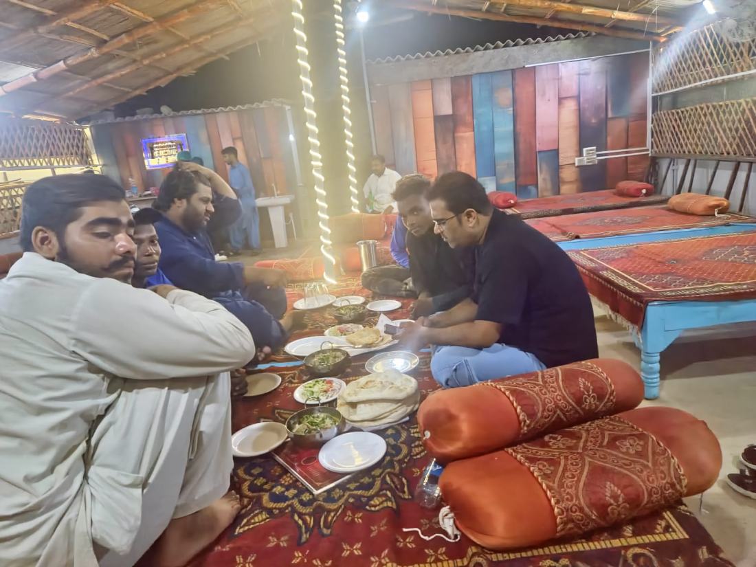Team members sharing dinner on floor seating
